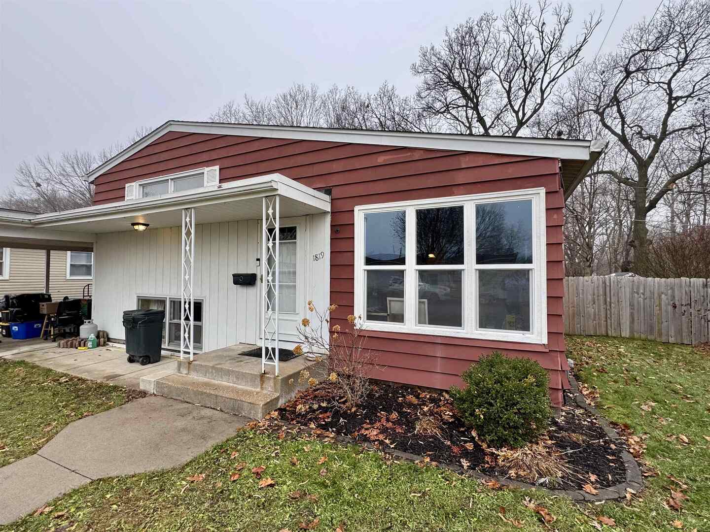 a front view of a house with a garden and chairs