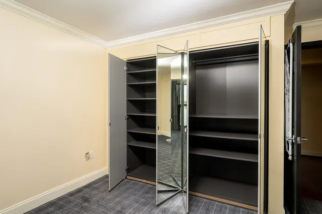 a view of walk in closet with empty racks