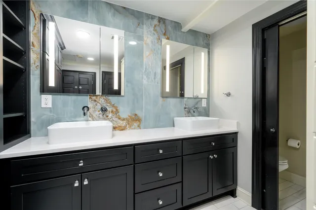 a bathroom with double sink and two mirror