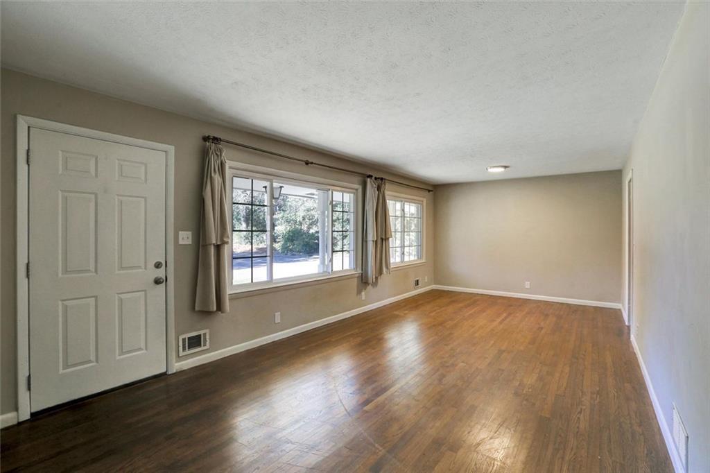 1266 Hickory Drive Southwest Lilburn, GA 30047 - Photo 12 of 49 a view of an empty room with wooden floor and a window