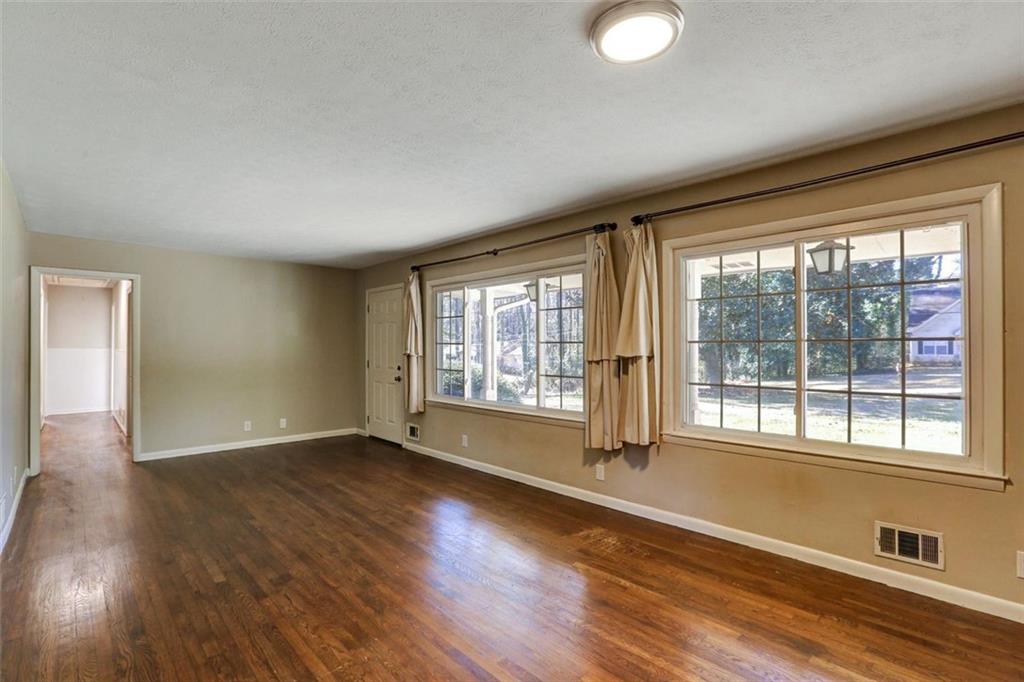 1266 Hickory Drive Southwest Lilburn, GA 30047 - Photo 13 of 49 a view of an empty room with wooden floor and a window