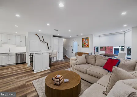a living room with furniture and a wooden floor