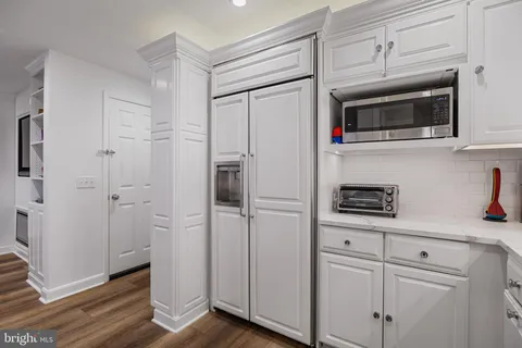 a kitchen with white cabinets and white appliances