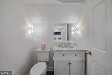 a bathroom with a sink toilet vanity and mirror
