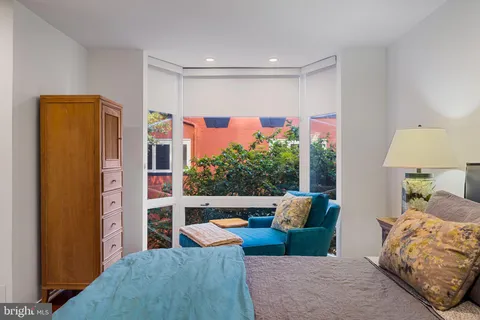 a bedroom with a bed a flat screen tv and a couch