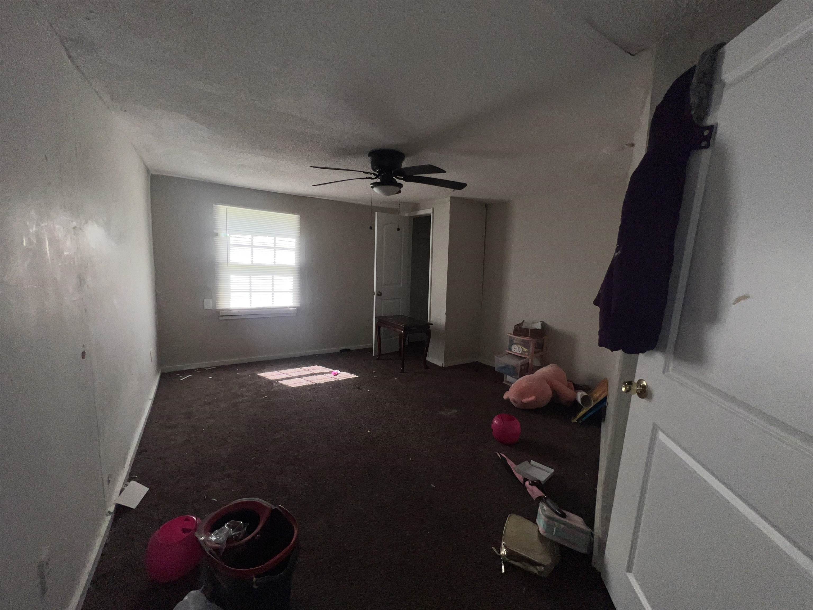 3044 Green Road Memphis, TN 38109 - Photo 12 of 15 Unfurnished bedroom with dark colored carpet, a ceiling fan, and a textured ceiling