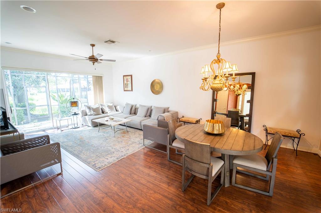 5886 Paradise Circle Naples, FL 34110 - Photo 7 of 19 Dining space featuring ceiling fan with notable chandelier, crown molding, and dark wood-type flooring