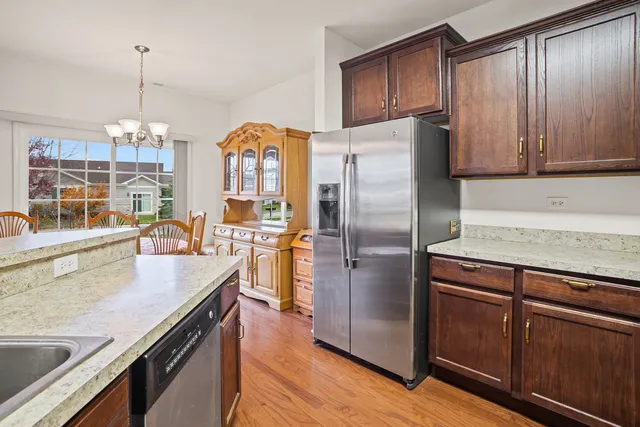 a kitchen with stainless steel appliances granite countertop a refrigerator a stove and a wooden floors