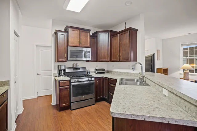 a kitchen with stainless steel appliances granite countertop a stove top oven a sink and dishwasher
