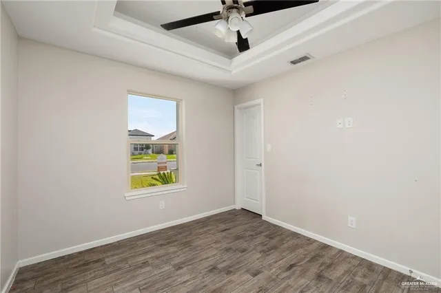 an empty room with window and wooden floor