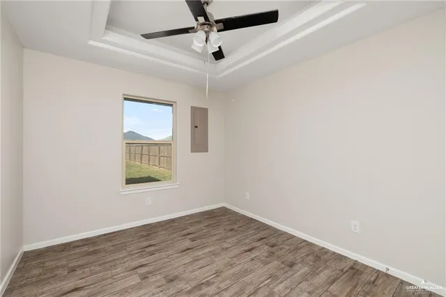 an empty room with a window and a ceiling fan