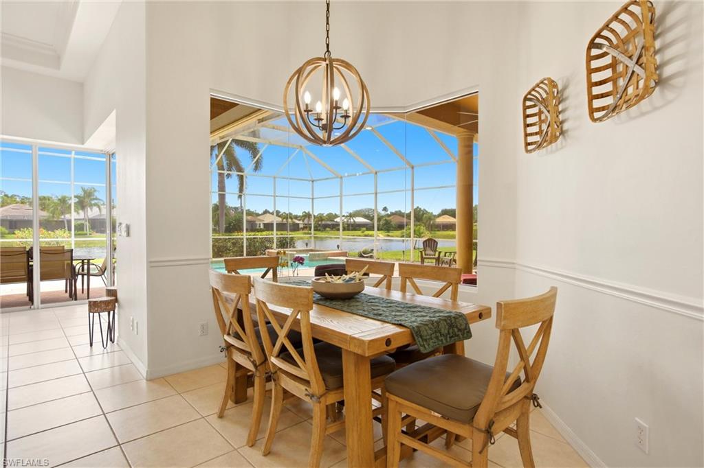 10815 Phoenix Way Naples, FL 34119 - Photo 11 of 40 a view of a dining room with furniture wooden floor and a chandelier