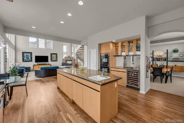 a large white kitchen with kitchen island a large counter top space a sink and stainless steel appliances