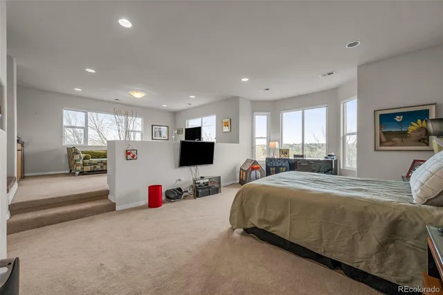 a living room with furniture a flat screen tv and a window