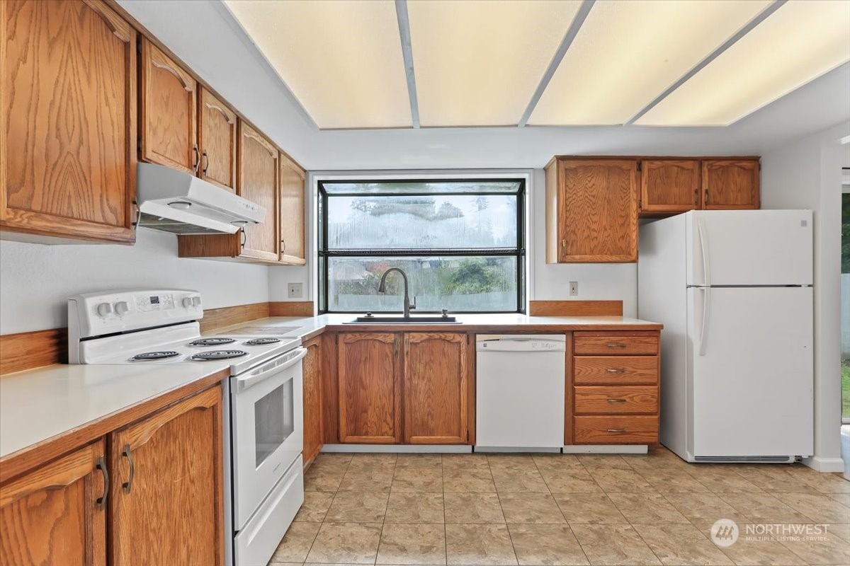 32744 30th Avenue Southwest Federal Way, WA 98023 - Photo 12 of 28 a kitchen with stainless steel appliances granite countertop a refrigerator and a stove top oven