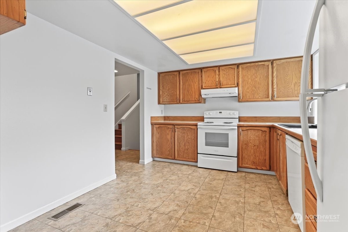 32744 30th Avenue Southwest Federal Way, WA 98023 - Photo 13 of 28 a kitchen with a stove sink and a refrigerator