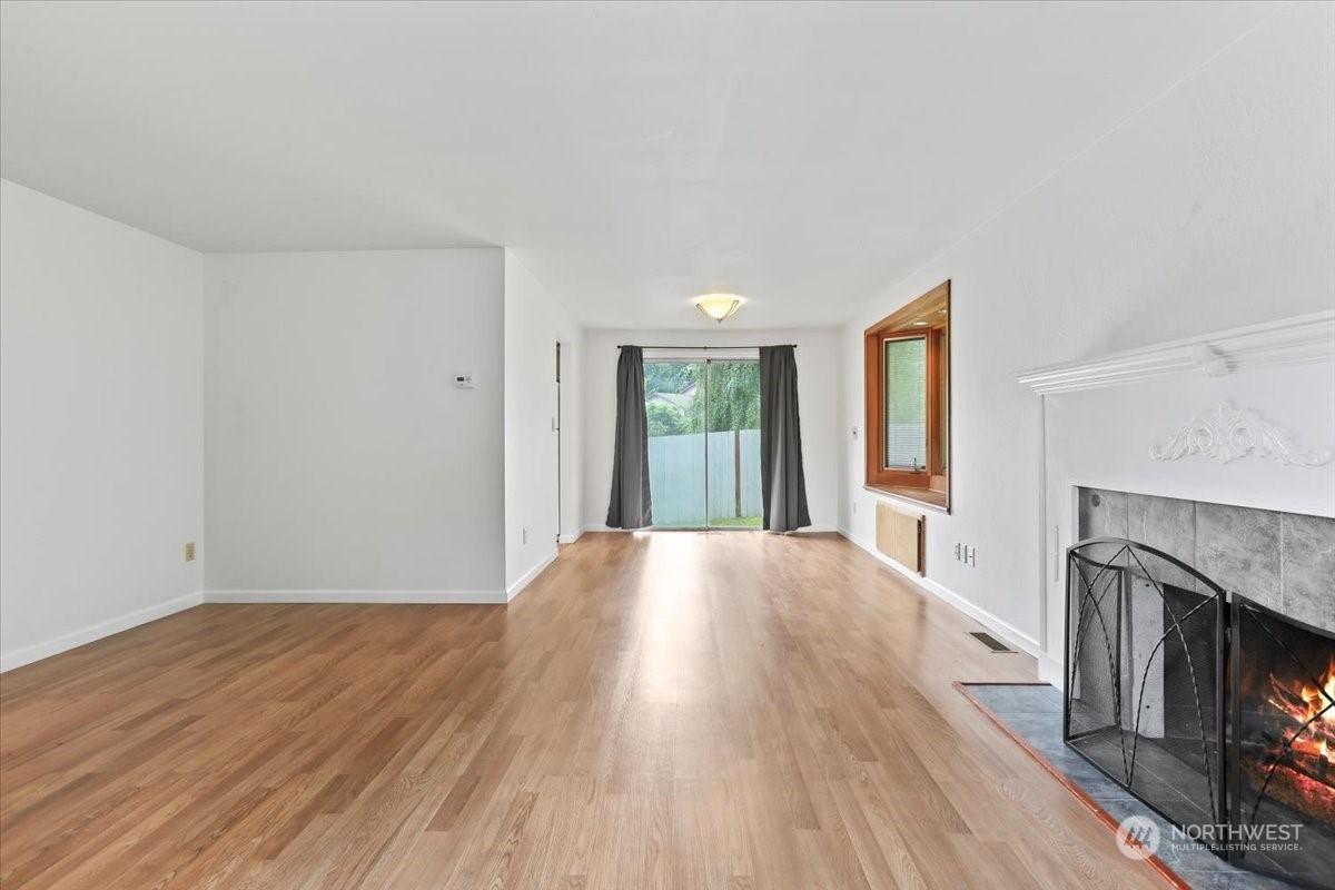 32744 30th Avenue Southwest Federal Way, WA 98023 - Photo 8 of 28 a view of an empty room with wooden floor fireplace and a window