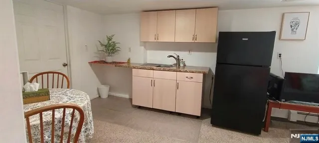 a kitchen with stainless steel appliances granite countertop a refrigerator sink and white cabinets