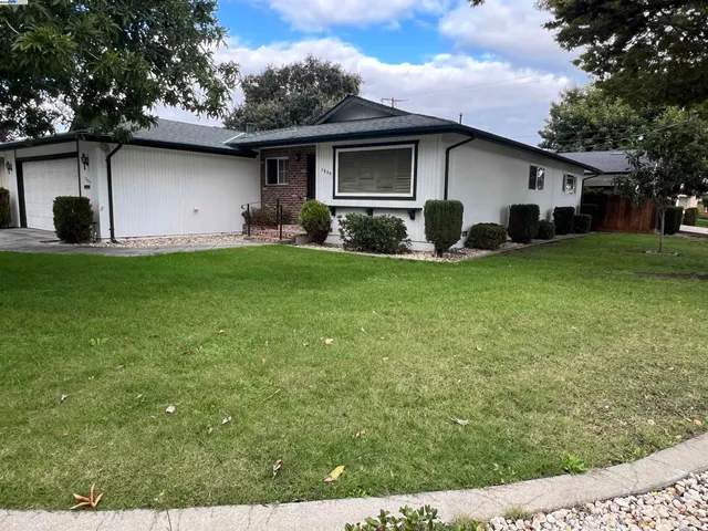 a front view of house with a garden