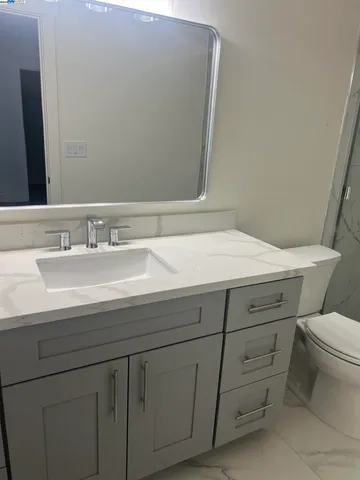 a bathroom with a sink toilet and mirror