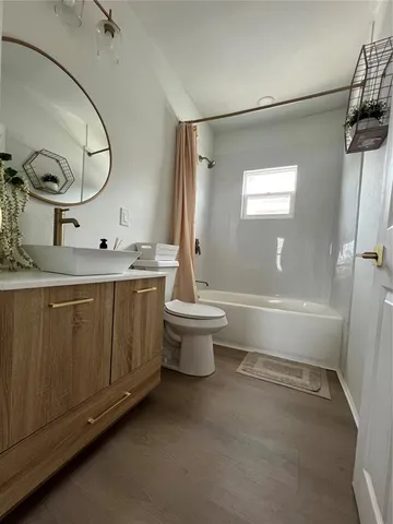a bathroom with a double vanity sink toilet mirror and shower