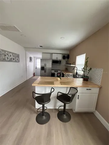a view of kitchen with kitchen island stainless steel appliances sink stove and refrigerator