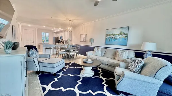 a living room with furniture and a view of kitchen
