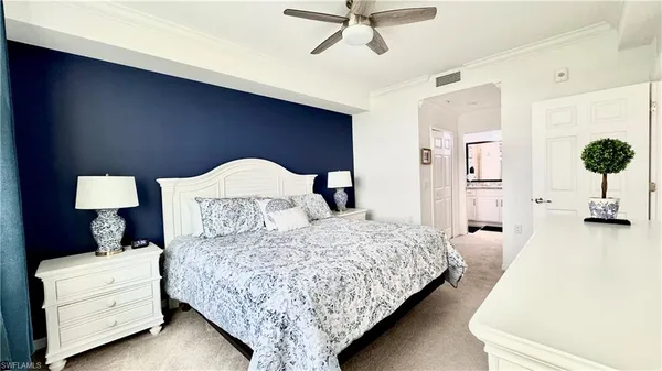 a bedroom with a large bed and a flat tv screen on dresser