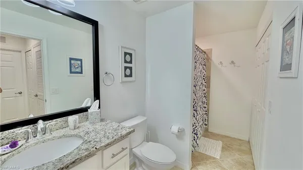 a bathroom with a granite countertop sink toilet and shower