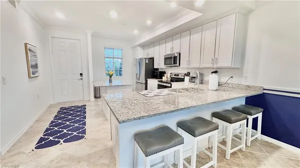 a kitchen with stainless steel appliances granite countertop a sink and a white cabinets
