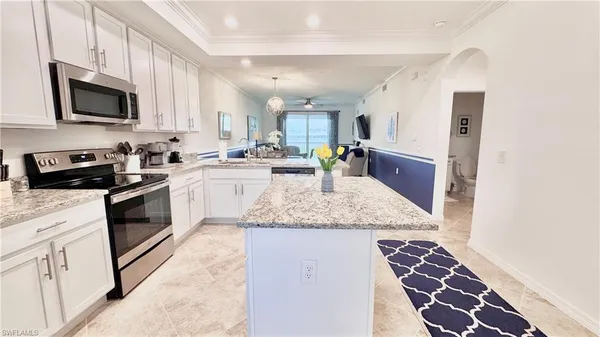 a kitchen with stainless steel appliances granite countertop a sink stove and microwave
