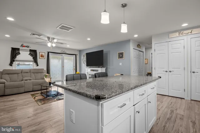 a kitchen with stainless steel appliances granite countertop a sink stove and wooden floor