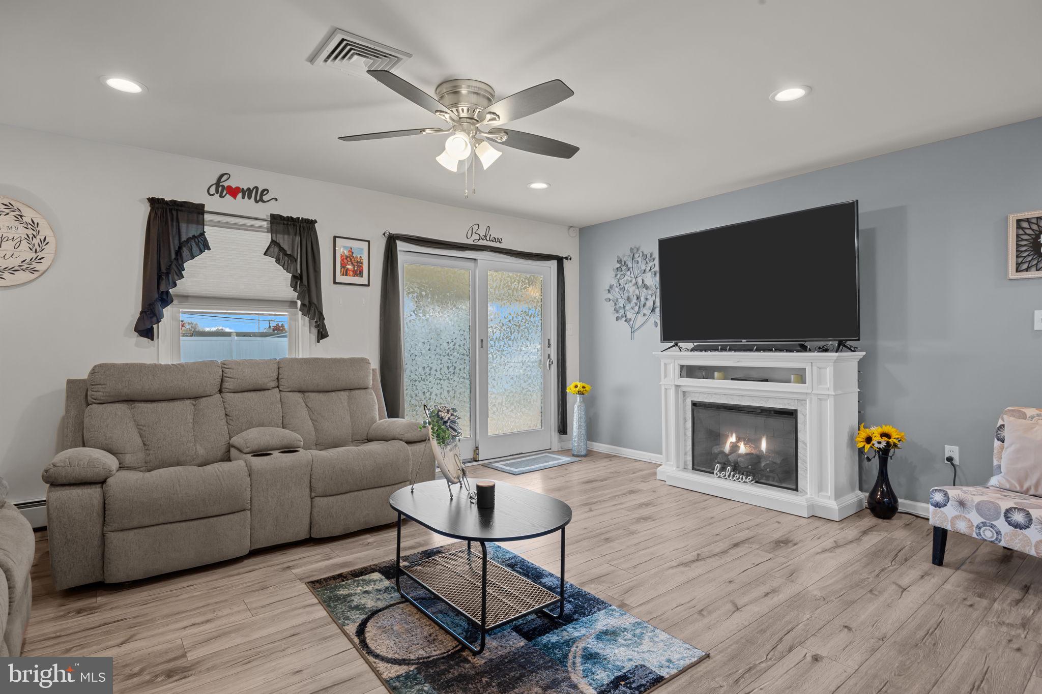179 Crabtree Drive Levittown, PA 19055 - Photo 9 of 25 a living room with furniture a flat screen tv and a fireplace