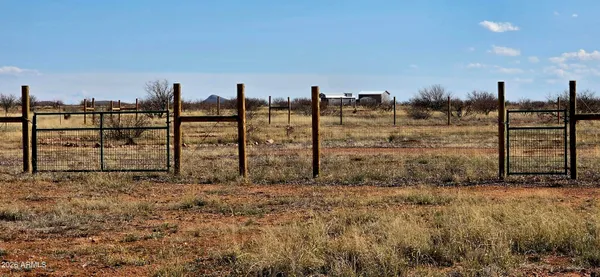 a view of a pathway with a wrought fence