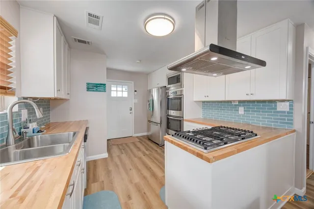 a kitchen with white cabinets and stainless steel appliances