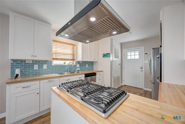 a kitchen with granite countertop a sink stainless steel appliances and cabinets