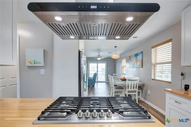 a kitchen with white cabinets appliances and a window
