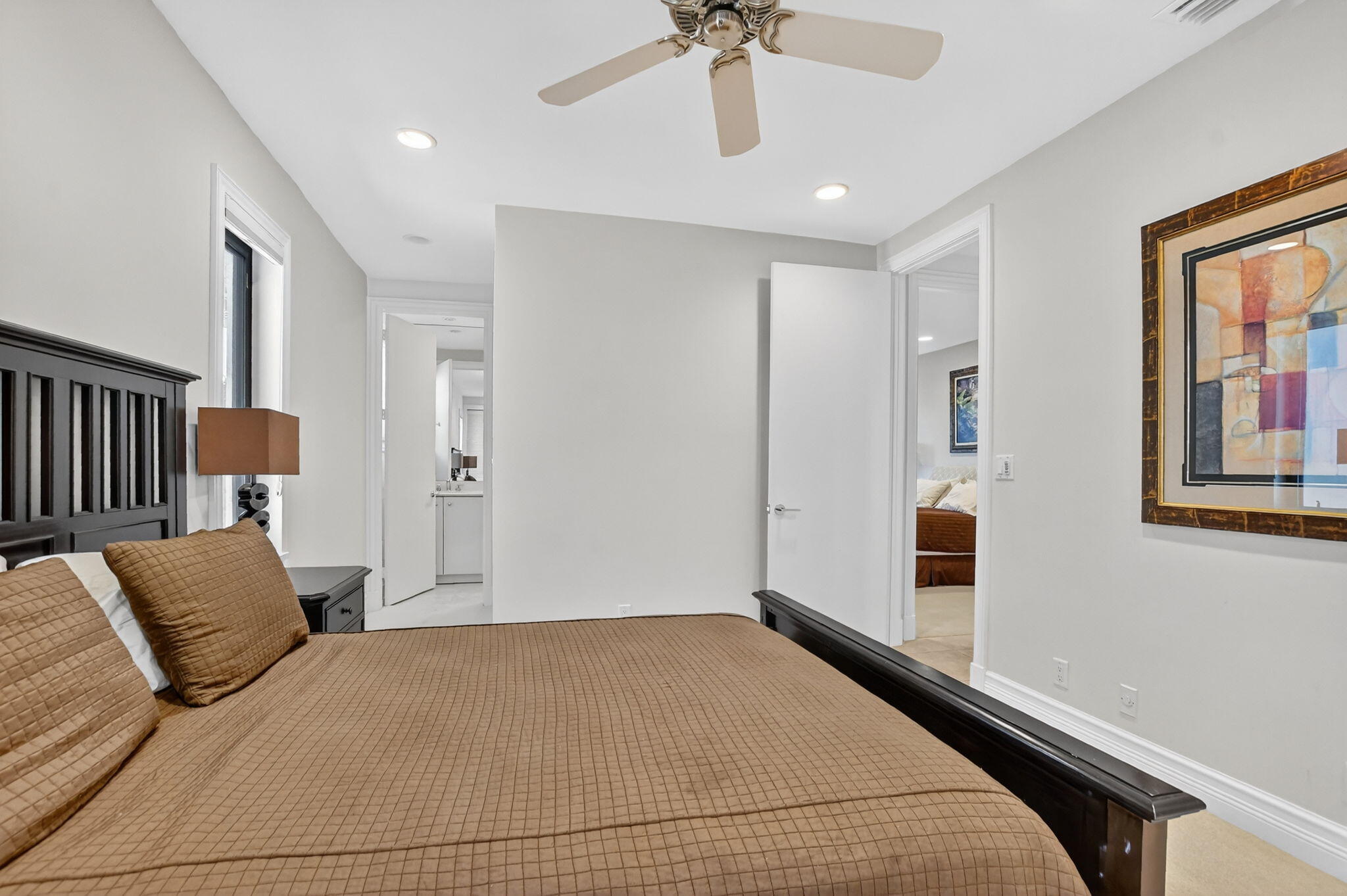 7567 Rexford Road Boca Raton, FL 33434 - Photo 38 of 95 a bedroom with a large bed and a chandelier