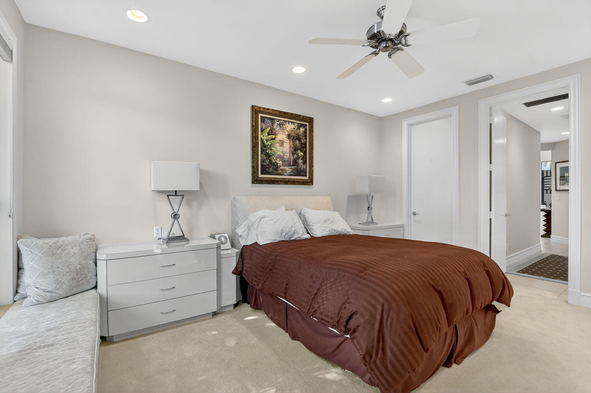 7567 Rexford Road Boca Raton, FL 33434 - Photo 44 of 95 a spacious bedroom with a bed and a lamp