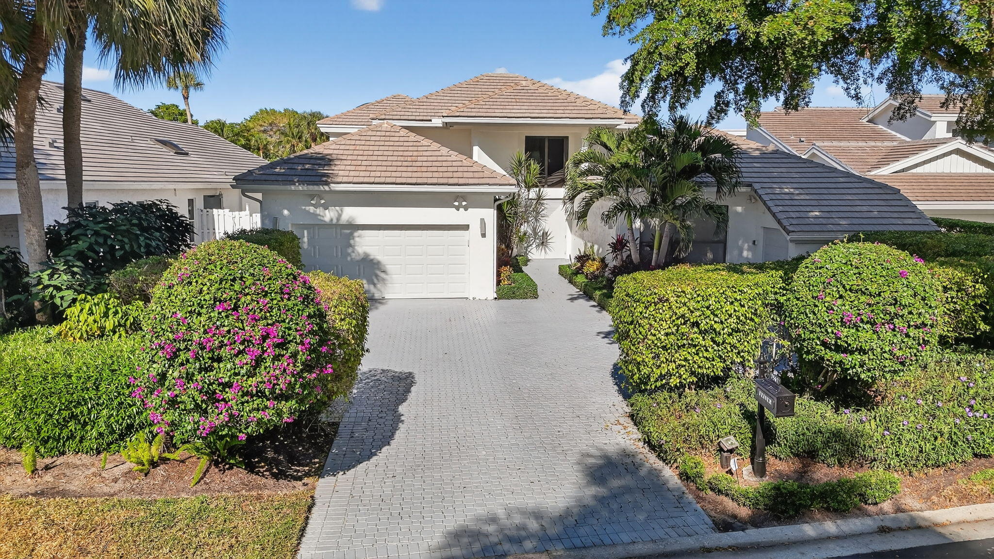 7567 Rexford Road Boca Raton, FL 33434 - Photo 62 of 95 a front view of a house with a yard and potted plants