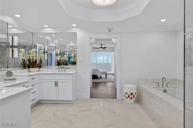 a large bathroom with a large tub sink vanity and granite