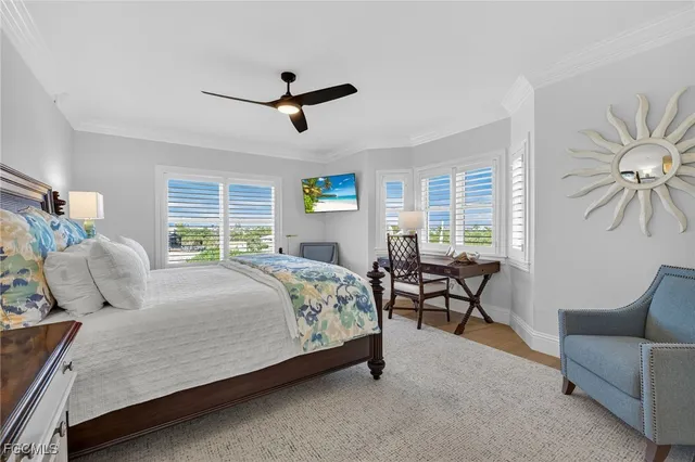 a bedroom with a bed a desk and chair with window