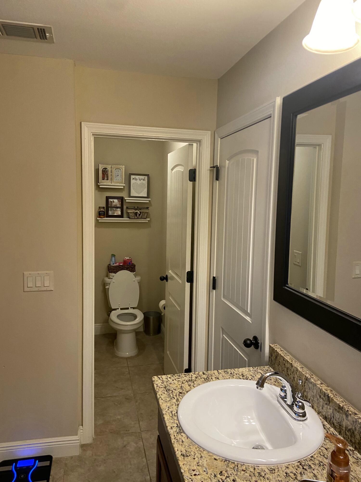 516 Grand Ridge Drive Crestview, FL 32539 - Photo 25 of 30 a bathroom with a granite countertop sink a toilet and a mirror