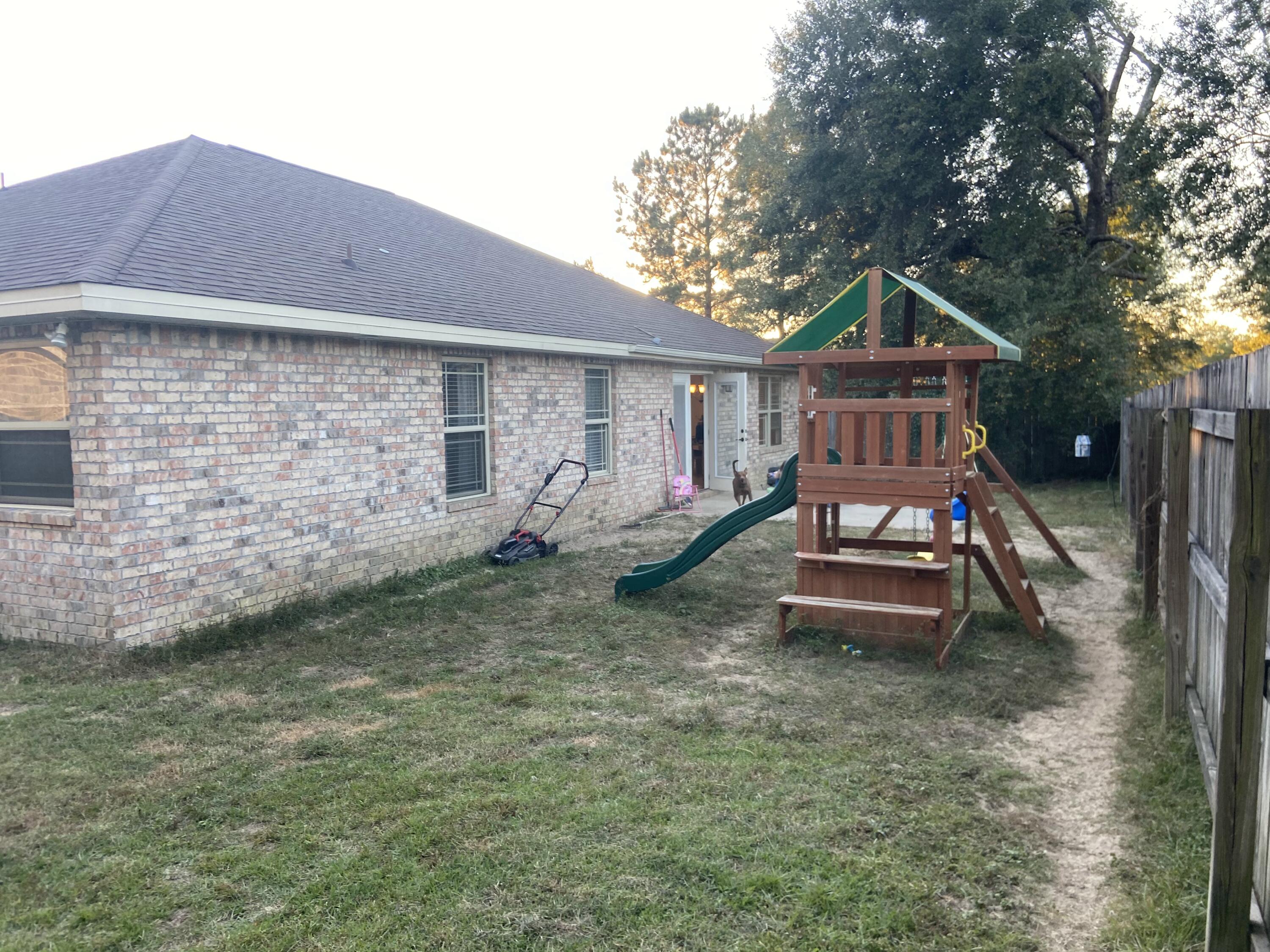 516 Grand Ridge Drive Crestview, FL 32539 - Photo 29 of 30 a backyard of a house with table and chairs