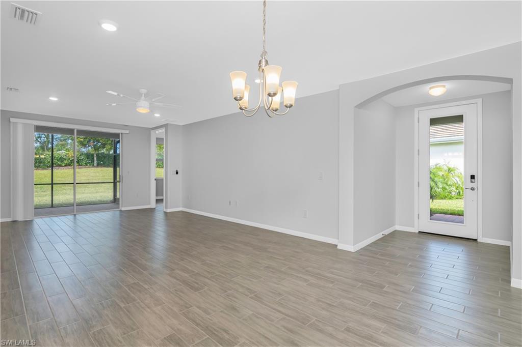 14559 Edgewater Circle Naples, FL 34114 - Photo 8 of 49 a view of an empty room with wooden floor and a window