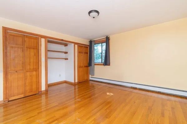 a view of an empty room with closet and a window