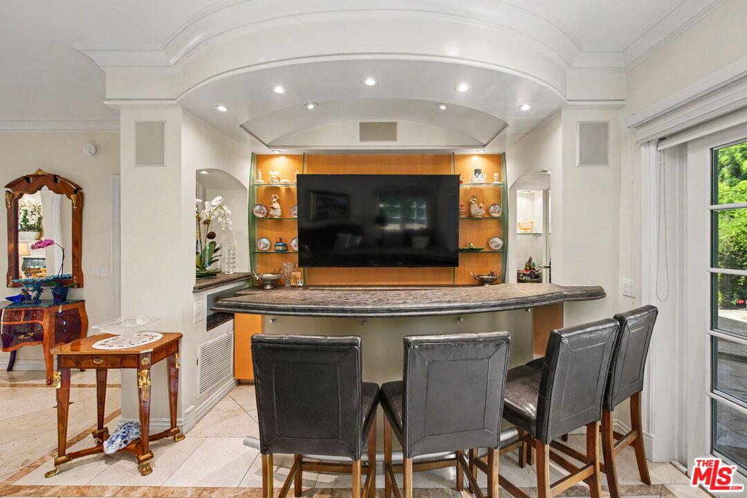 204 Foothill Road Beverly Hills, CA 90210 - Photo 14 of 38 a kitchen with stainless steel appliances a dining table and chairs
