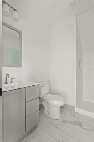 a bathroom with a toilet a sink a vanity and mirror