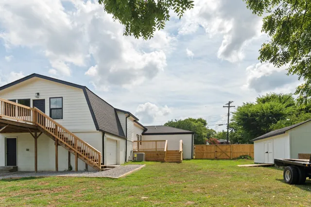 a view of a house with a big yard and large trees
