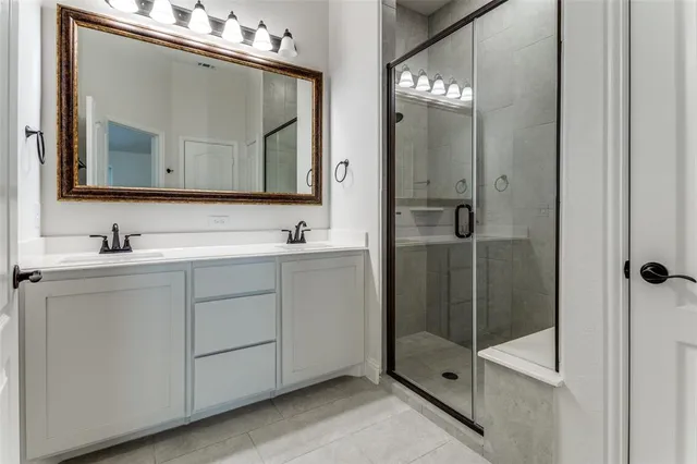 a bathroom with a double vanity sink mirror and shower